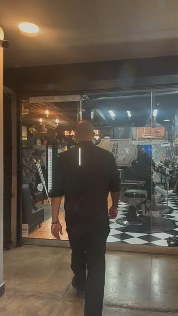 Cliente entrando a la barbería por el piso ajedrezado