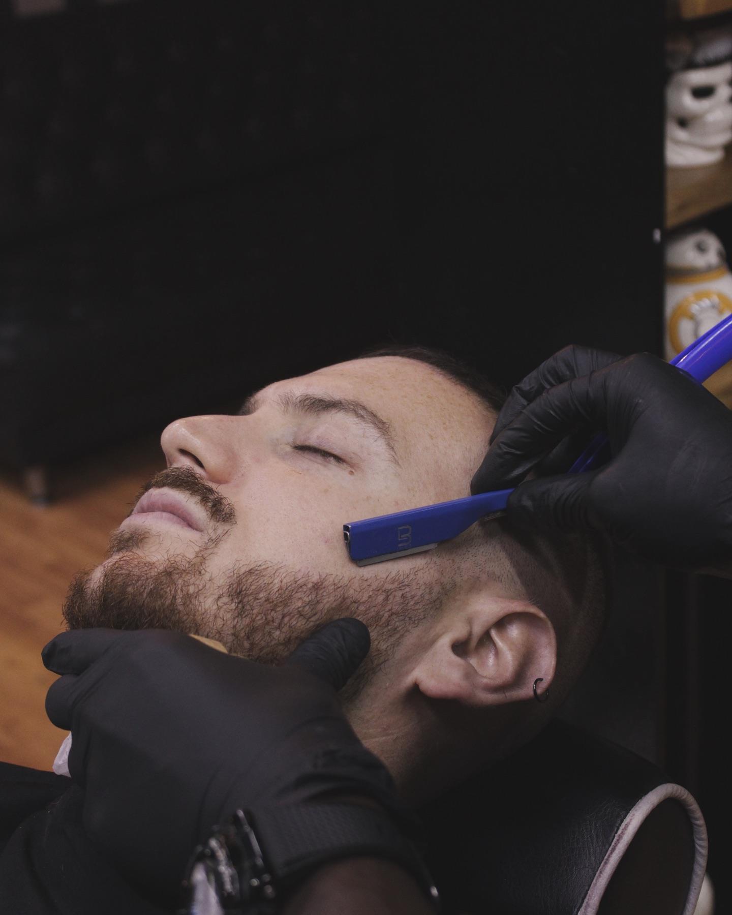 Perfilado de barba con navaja y guantes negros