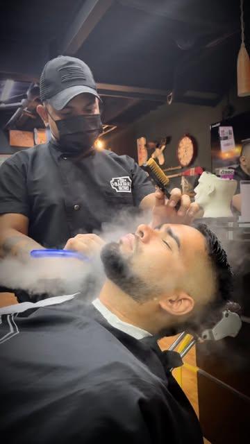 Toalla caliente con vapor sobre el rostro de un cliente
